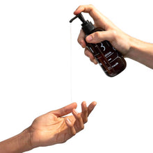 Charger l'image dans la galerie, Main faisant couler du lubrifiant à base de silicone Shine de Maude sur fond blanc