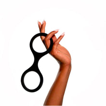Charger l'image dans la galerie, Main tenant les menottes en silicone sans attaches Clink de Wednesday Co. sur fond blanc