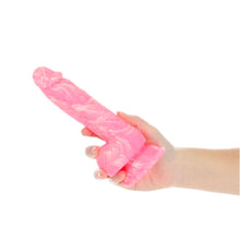 Charger l'image dans la galerie, Main tenant le dildo en silicone rose marbré luminescent par Addiction sur fond blanc