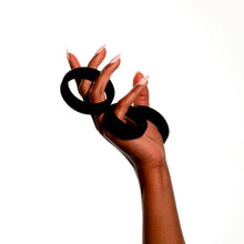 Charger l&#39;image dans la galerie, Main tenant trois anneaux péniens en PVC noir de Wednesday co. sur fond blanc
