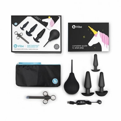 Ensemble d'initiation au sexe anal noir par B-Vibe sur fond blanc : boîte d'emballage, guide d'instruction, trois plugs anales, applicateur de lubrifiant, poire de lavement, étui de transport et câble de recharge
